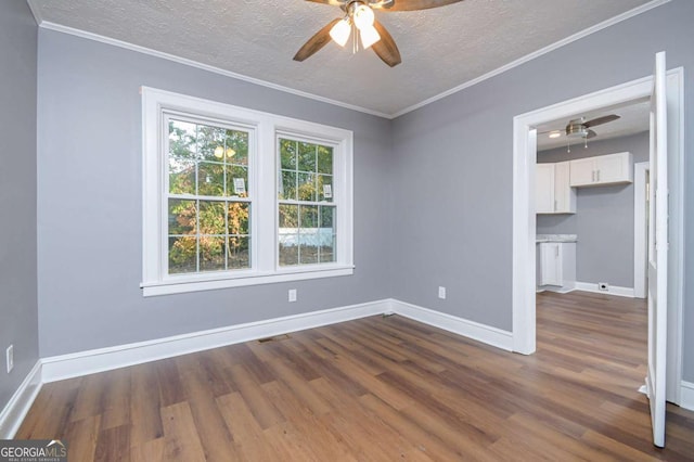 unfurnished room featuring crown molding, dark hardwood / wood-style floors, and a textured ceiling