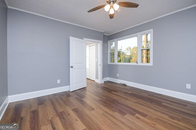 empty room featuring crown molding, ceiling fan, and dark hardwood / wood-style flooring