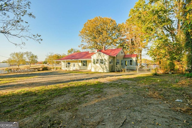 rear view of house featuring a yard and covered porch