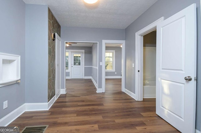 hallway with dark hardwood / wood-style flooring and a textured ceiling