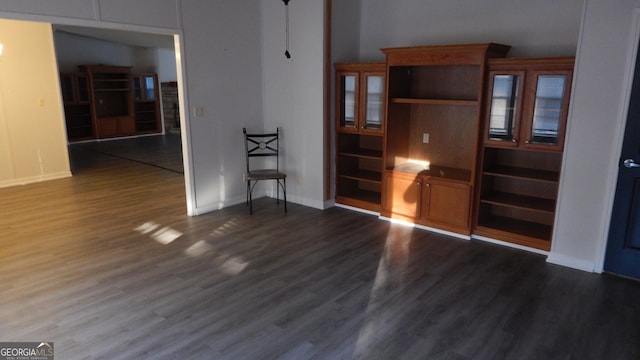 unfurnished living room with dark wood-type flooring