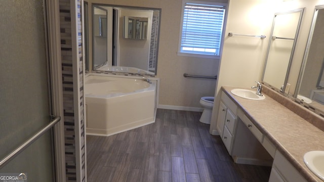 bathroom with wood-type flooring, a tub, vanity, and toilet