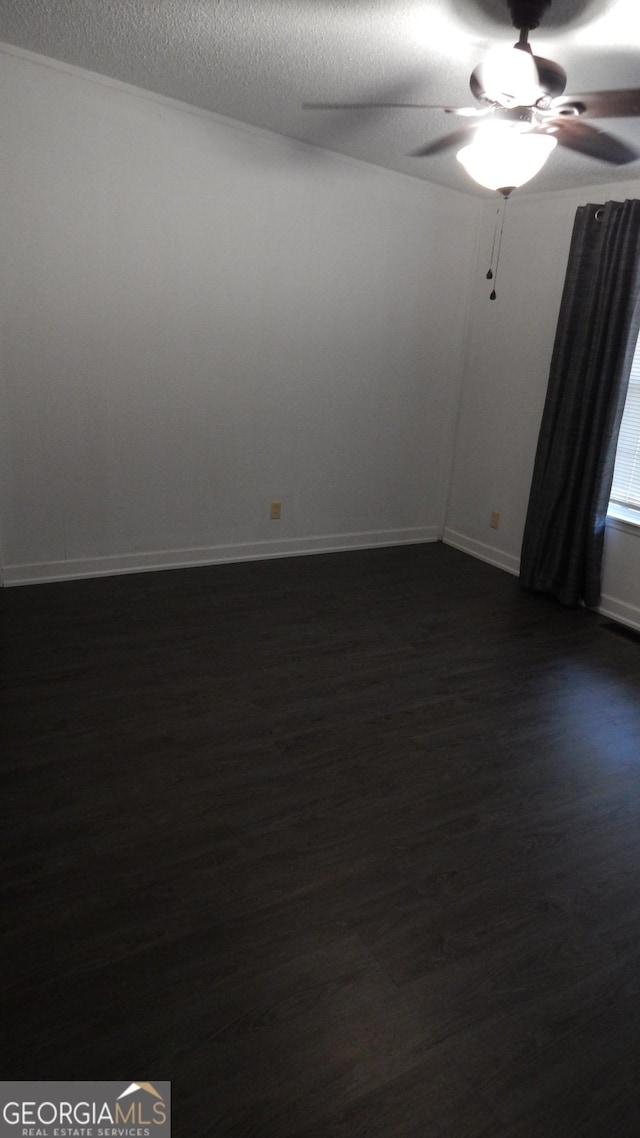 spare room with ceiling fan, dark hardwood / wood-style floors, and a textured ceiling