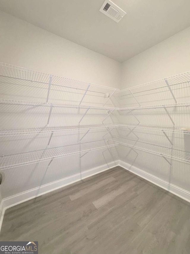 spacious closet with visible vents and dark wood-style flooring