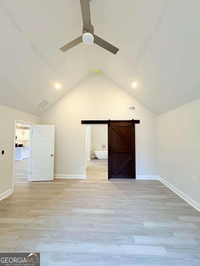 additional living space with baseboards, visible vents, vaulted ceiling, and light wood finished floors