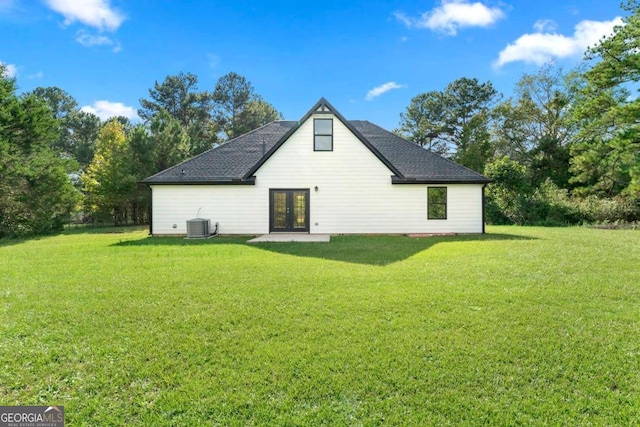 rear view of house with central air condition unit, a yard, and french doors