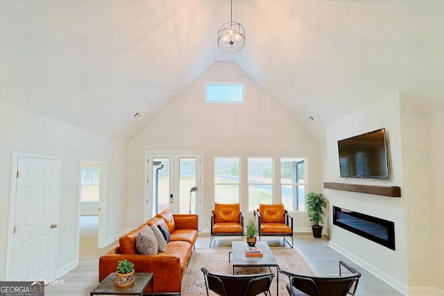 living room with high vaulted ceiling, baseboards, french doors, light wood finished floors, and a glass covered fireplace