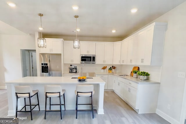 kitchen featuring appliances with stainless steel finishes, decorative backsplash, a kitchen breakfast bar, and a center island