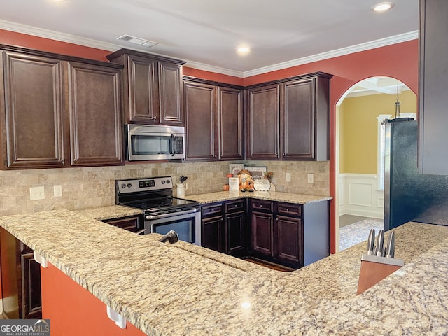 kitchen featuring light stone counters, crown molding, tasteful backsplash, kitchen peninsula, and stainless steel appliances