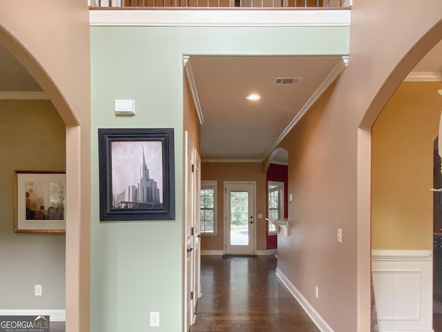 hallway featuring ornamental molding, dark hardwood / wood-style floors, and a high ceiling