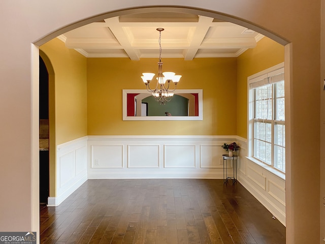 unfurnished room with beam ceiling, coffered ceiling, dark hardwood / wood-style floors, and a chandelier