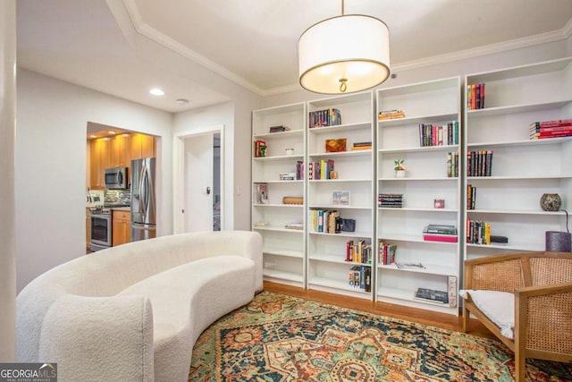 living area with hardwood / wood-style floors and crown molding