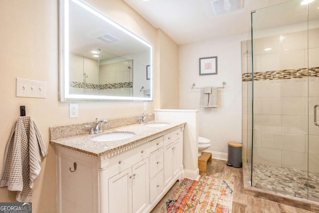 bathroom with walk in shower, vanity, and toilet