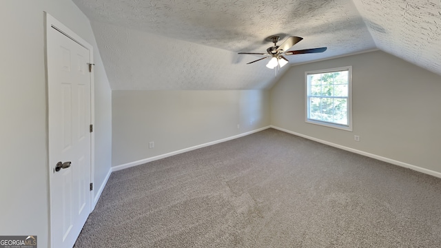 additional living space with ceiling fan, vaulted ceiling, a textured ceiling, and carpet