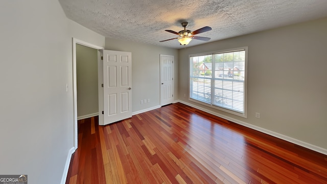 unfurnished bedroom featuring ceiling fan, hardwood / wood-style floors, and a textured ceiling