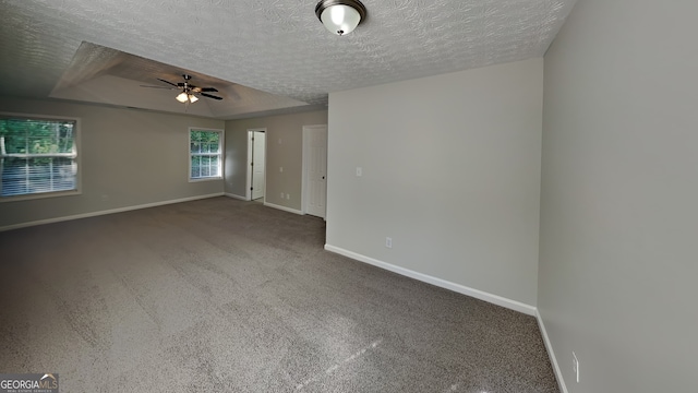 empty room featuring ceiling fan, carpet floors, and a textured ceiling