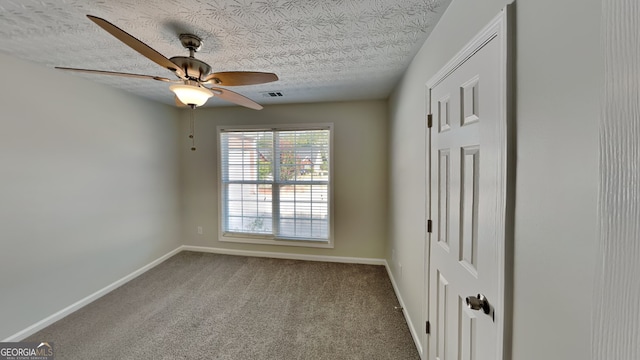 carpeted spare room with ceiling fan and a textured ceiling