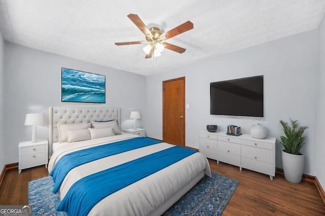 bedroom with ceiling fan, dark hardwood / wood-style flooring, and a textured ceiling