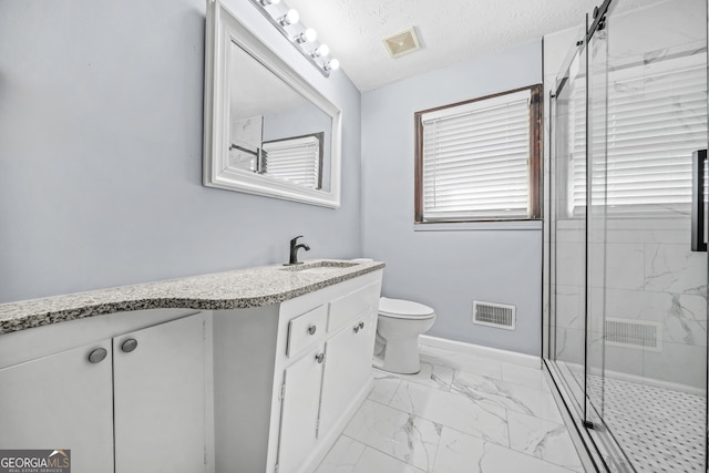 bathroom with vanity, toilet, an enclosed shower, and a textured ceiling