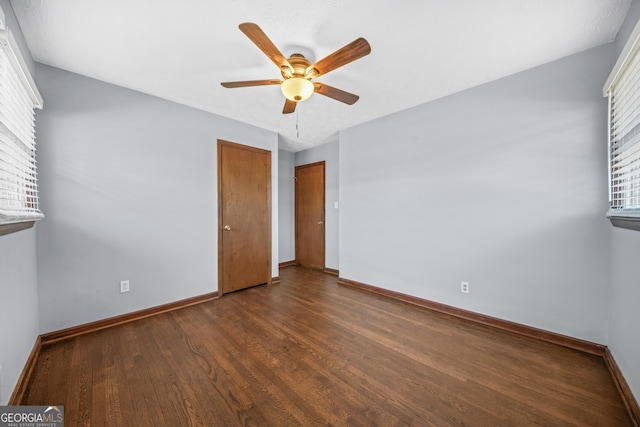 unfurnished bedroom featuring ceiling fan and dark hardwood / wood-style floors