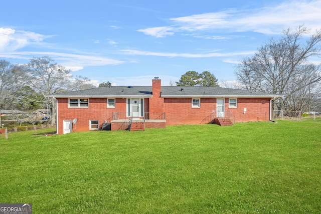 rear view of house featuring a lawn