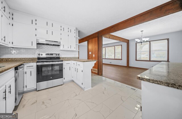 kitchen featuring decorative light fixtures, dark stone countertops, beamed ceiling, stainless steel appliances, and white cabinets