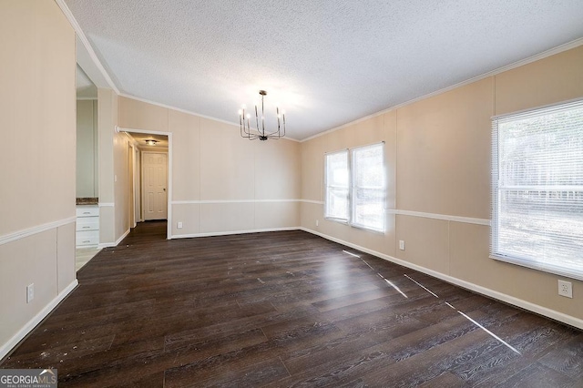 unfurnished dining area with dark wood-type flooring, ornamental molding, an inviting chandelier, and a textured ceiling