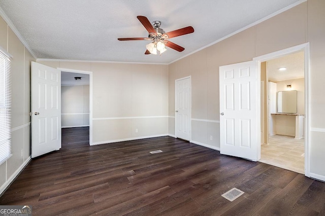 unfurnished bedroom featuring crown molding, ceiling fan, dark hardwood / wood-style flooring, and a closet