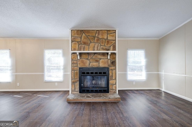 unfurnished living room featuring crown molding, a stone fireplace, dark hardwood / wood-style floors, and a textured ceiling