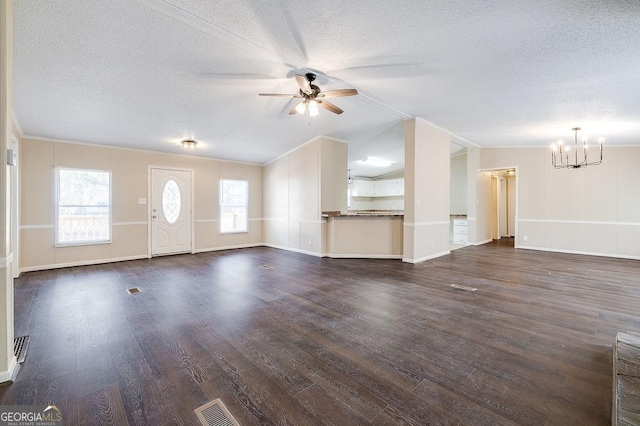 unfurnished living room featuring ceiling fan with notable chandelier, ornamental molding, dark hardwood / wood-style floors, and a textured ceiling