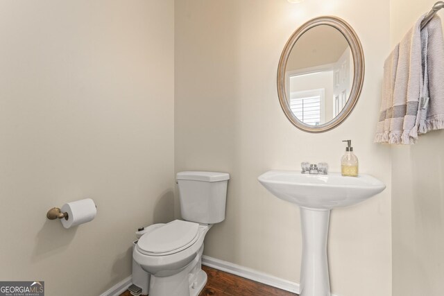 bathroom with wood-type flooring, sink, and toilet