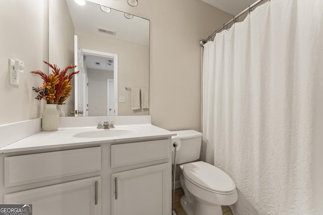 bathroom with vanity, curtained shower, and toilet