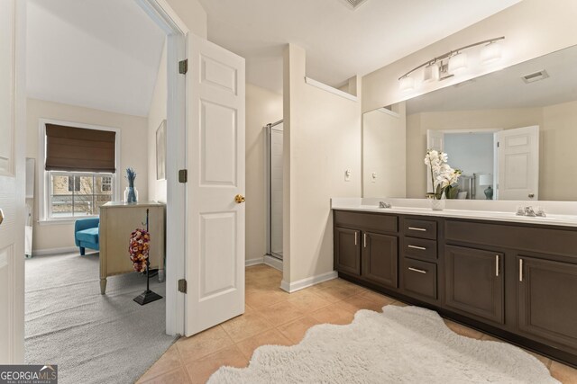 bathroom with walk in shower, vanity, and tile patterned flooring