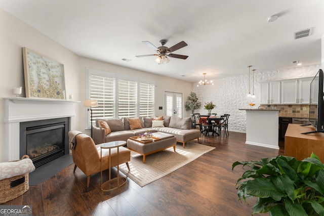 living room with dark hardwood / wood-style floors and ceiling fan with notable chandelier