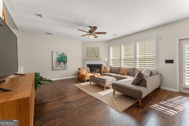 living room with dark wood-type flooring and ceiling fan