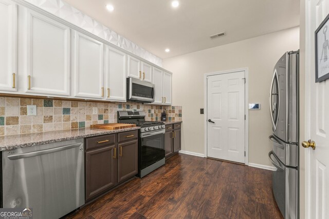 kitchen with white cabinetry, light stone countertops, backsplash, and stainless steel appliances