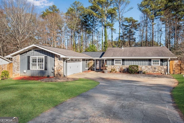 ranch-style home featuring a garage and a front yard