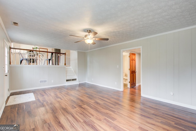 unfurnished room with wood-type flooring, crown molding, ceiling fan, and a textured ceiling