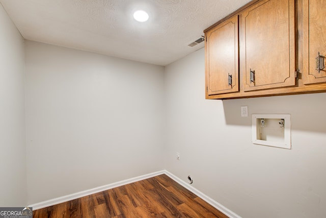 laundry area with cabinets, washer hookup, dark hardwood / wood-style floors, and a textured ceiling