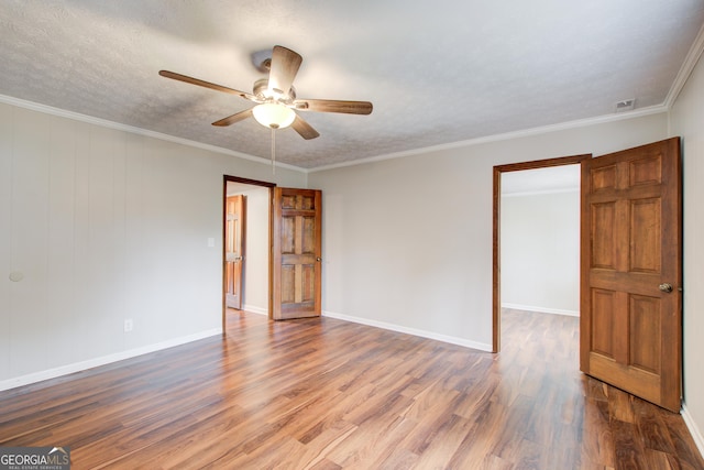 spare room with ceiling fan, crown molding, wood-type flooring, and a textured ceiling