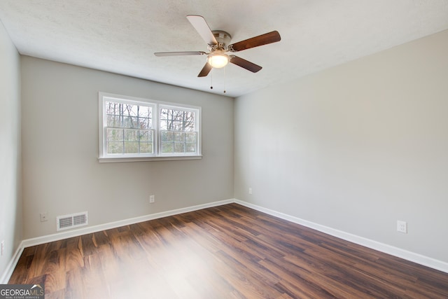 spare room with dark hardwood / wood-style flooring, a textured ceiling, and ceiling fan