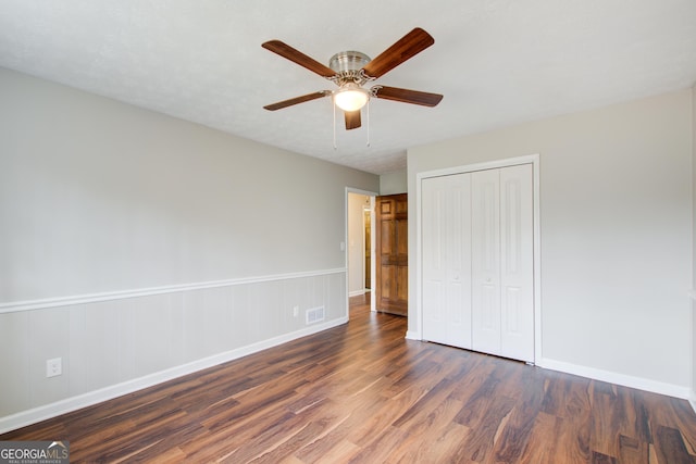 unfurnished bedroom featuring ceiling fan, dark hardwood / wood-style floors, and a closet