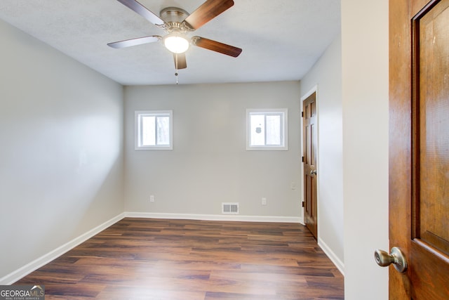 empty room featuring dark wood-type flooring and ceiling fan