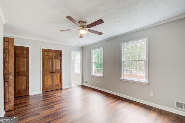 unfurnished bedroom featuring dark hardwood / wood-style flooring, ceiling fan, ornamental molding, and a textured ceiling