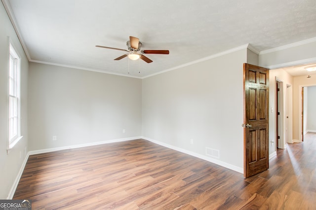 empty room featuring wood-type flooring, ceiling fan, and crown molding