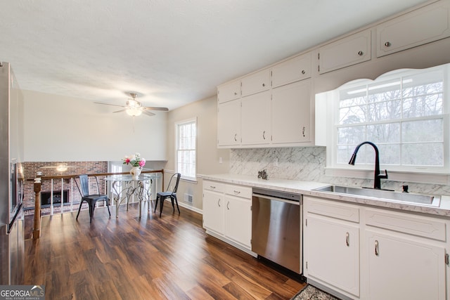 kitchen featuring dark hardwood / wood-style floors, white cabinetry, sink, backsplash, and stainless steel dishwasher