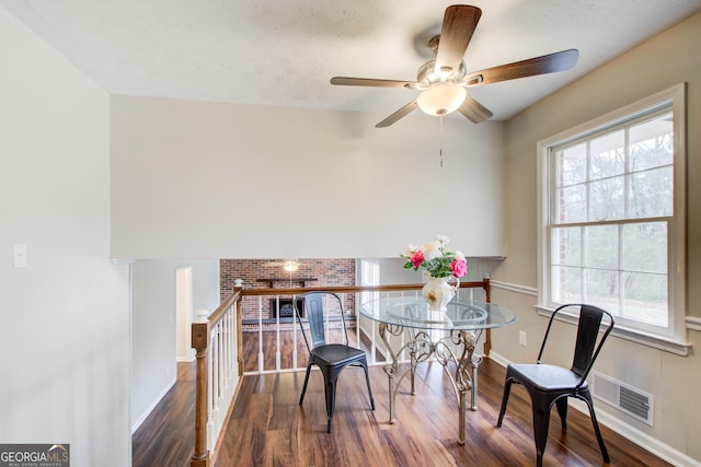 dining area with a wealth of natural light and dark hardwood / wood-style flooring