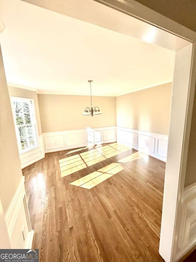 interior space with crown molding, hardwood / wood-style floors, and a notable chandelier