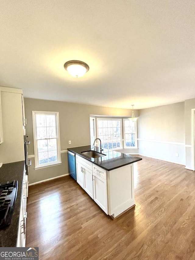 kitchen featuring sink, white cabinetry, decorative light fixtures, plenty of natural light, and hardwood / wood-style floors