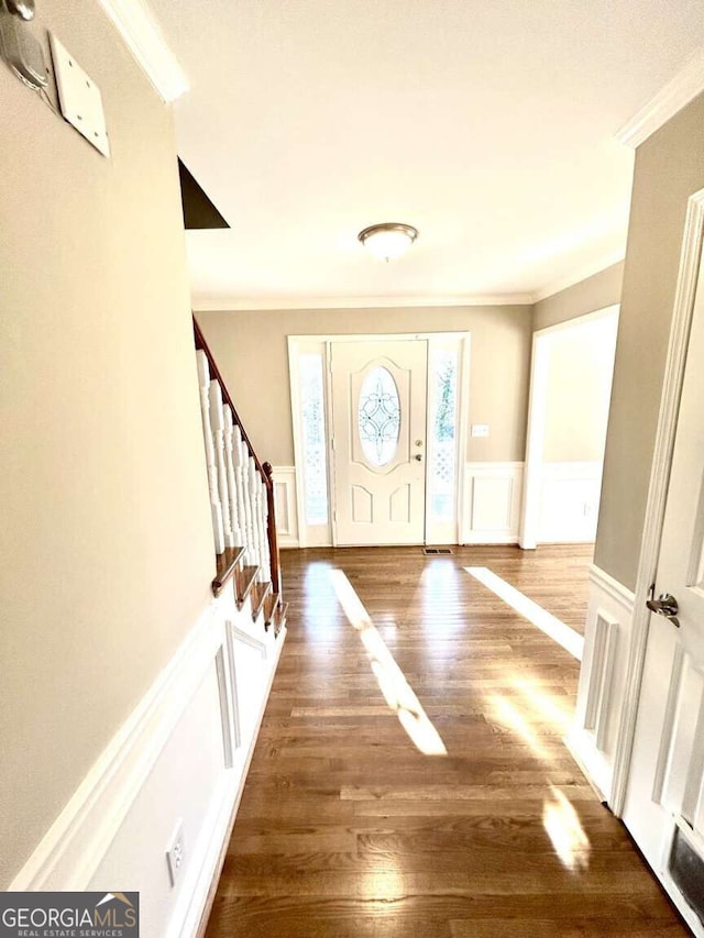 entrance foyer featuring crown molding and dark hardwood / wood-style flooring